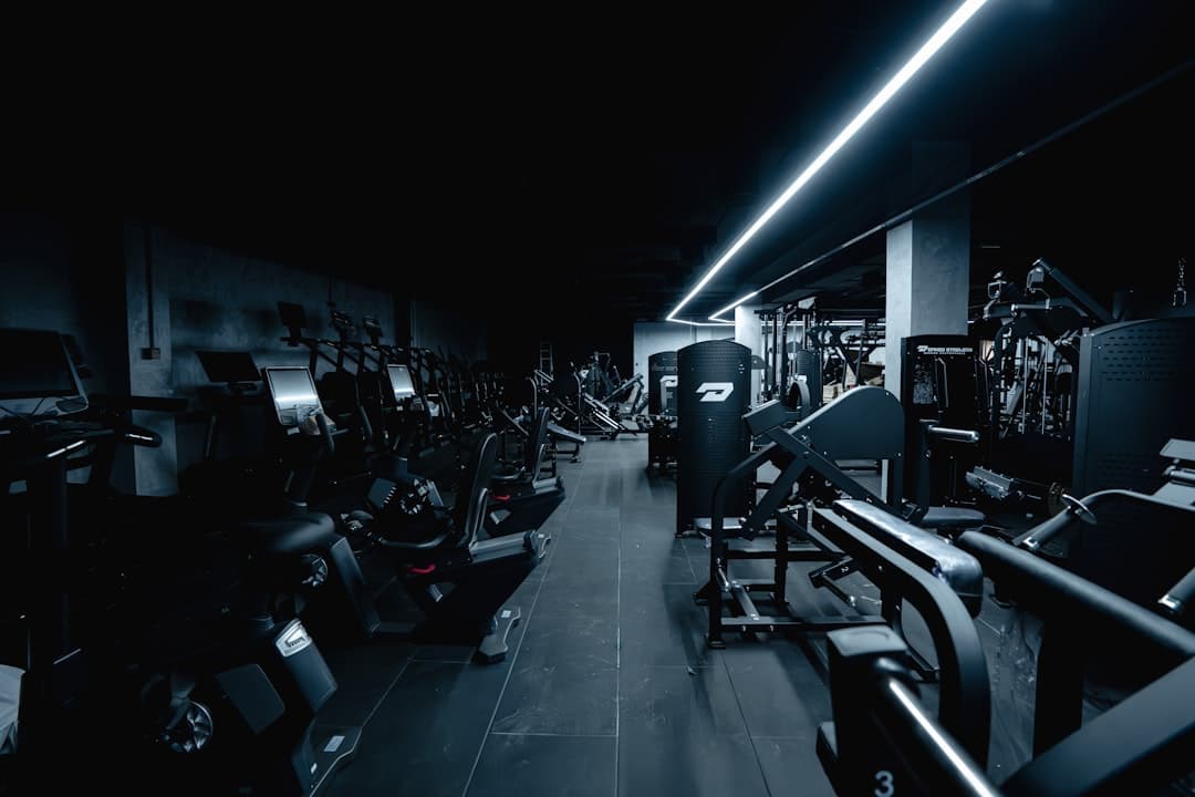 Dark gym interior with exercise equipment and weight machines.