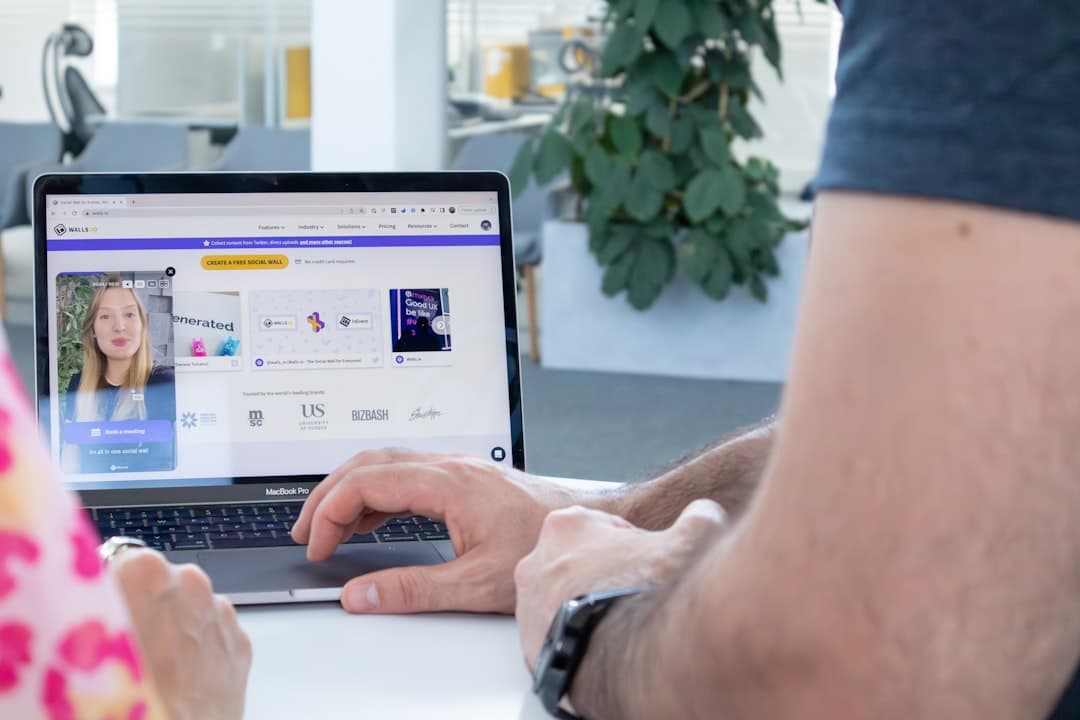 a man and a woman sitting at a table with a laptop